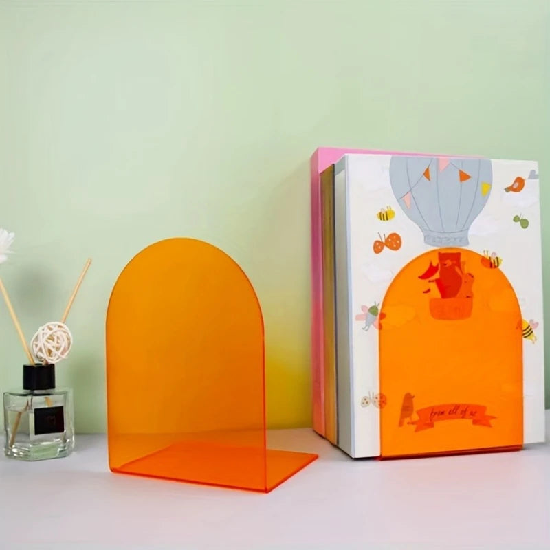 Orange arch-shaped acrylic bookend supporting books on a desk with a decorative background