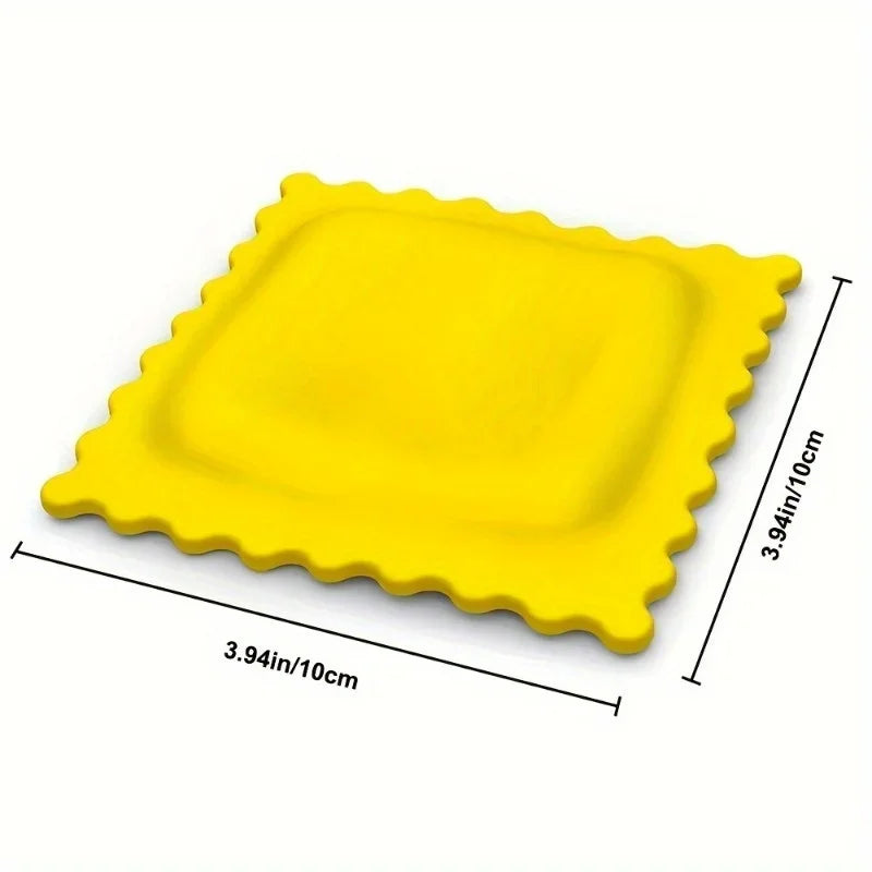Yellow biscuit-shaped silicone spoon rest with measurement lines showing 10cm by 10cm (3.94in by 3.94in)