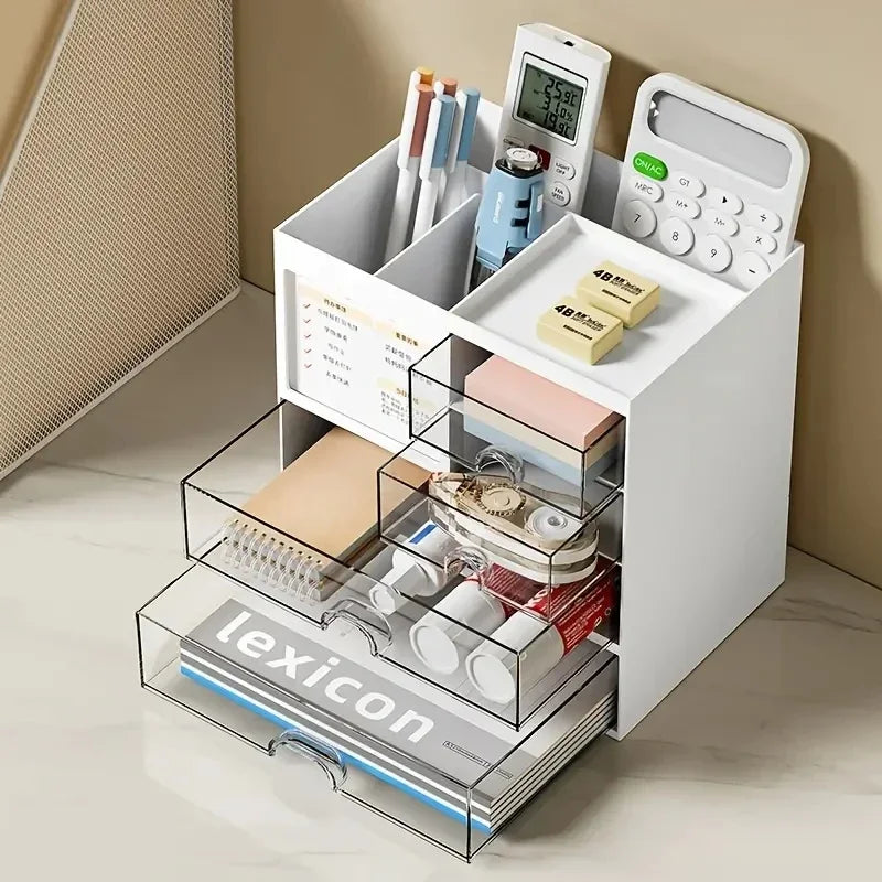 Open drawer organizer showing three compartments with stationery, calculators, and supplies on a light-colored desk