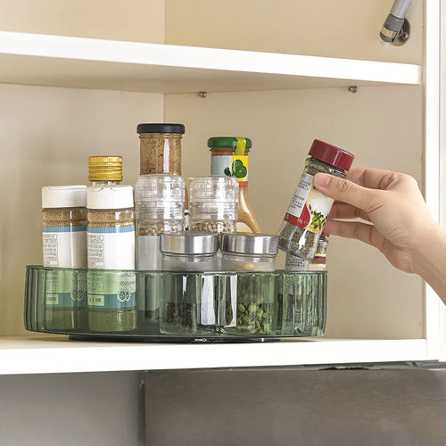 Green round PET lazy susan organizer in a pantry cabinet with spice jars