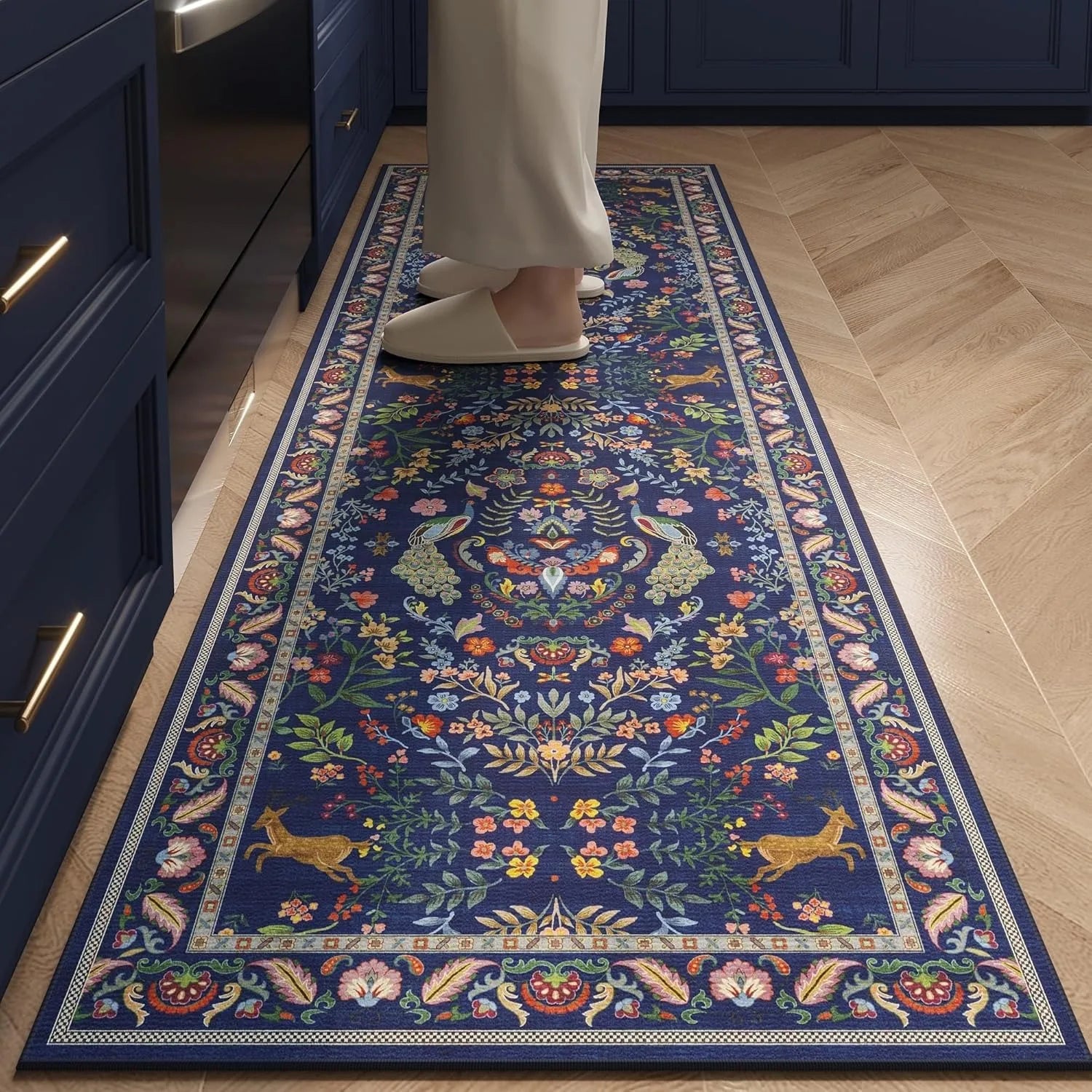 Blue Wilton floral non-slip kitchen runner rug placed in a modern kitchen with navy cabinetry