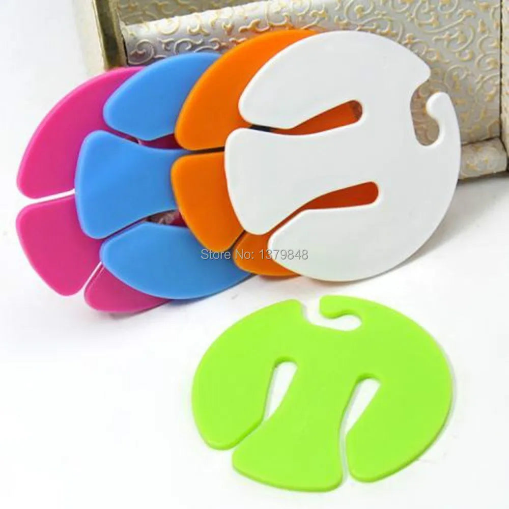 Stack of assorted colorful sock clips on a white surface with one green clip in front