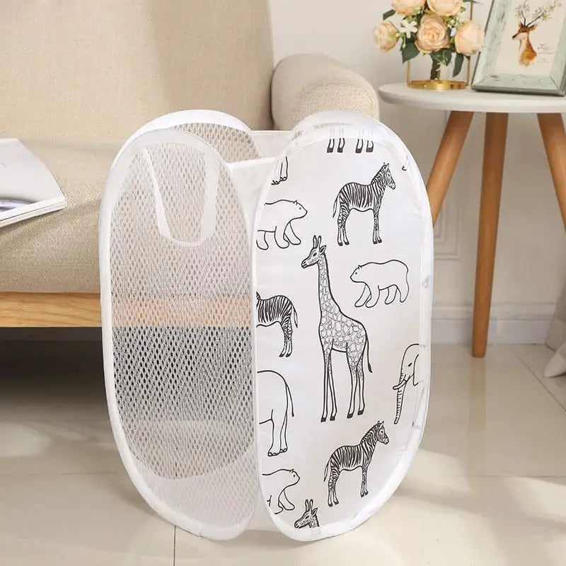 White mesh laundry hamper with animal design beside a sofa in a nursery or kids' room.