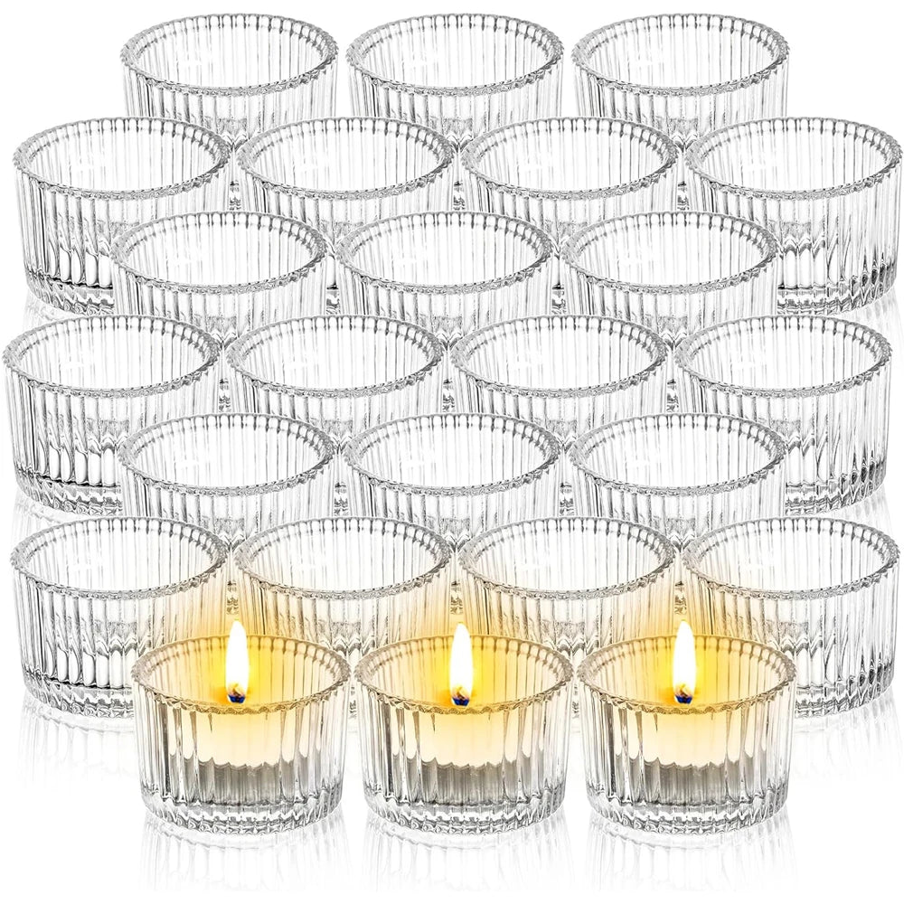 group of clear ribbed glass tealight candle holders with two tealights lit in front