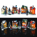 LED lighted Christmas village set with miniature houses, trees, and holiday figurines displayed on white and black backgrounds
