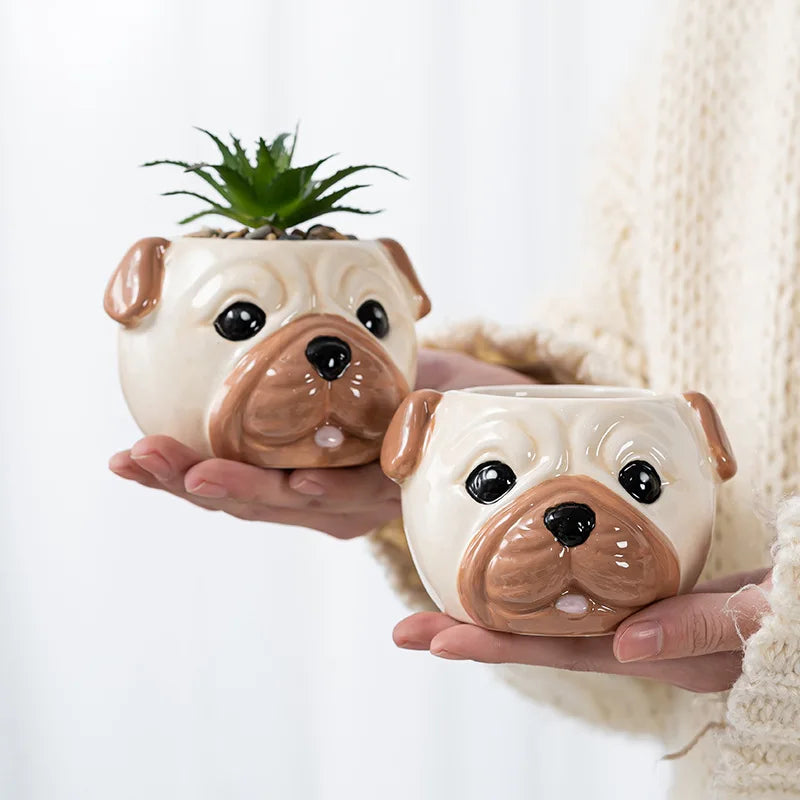 Hands holding two beige dog face porcelain mini planters