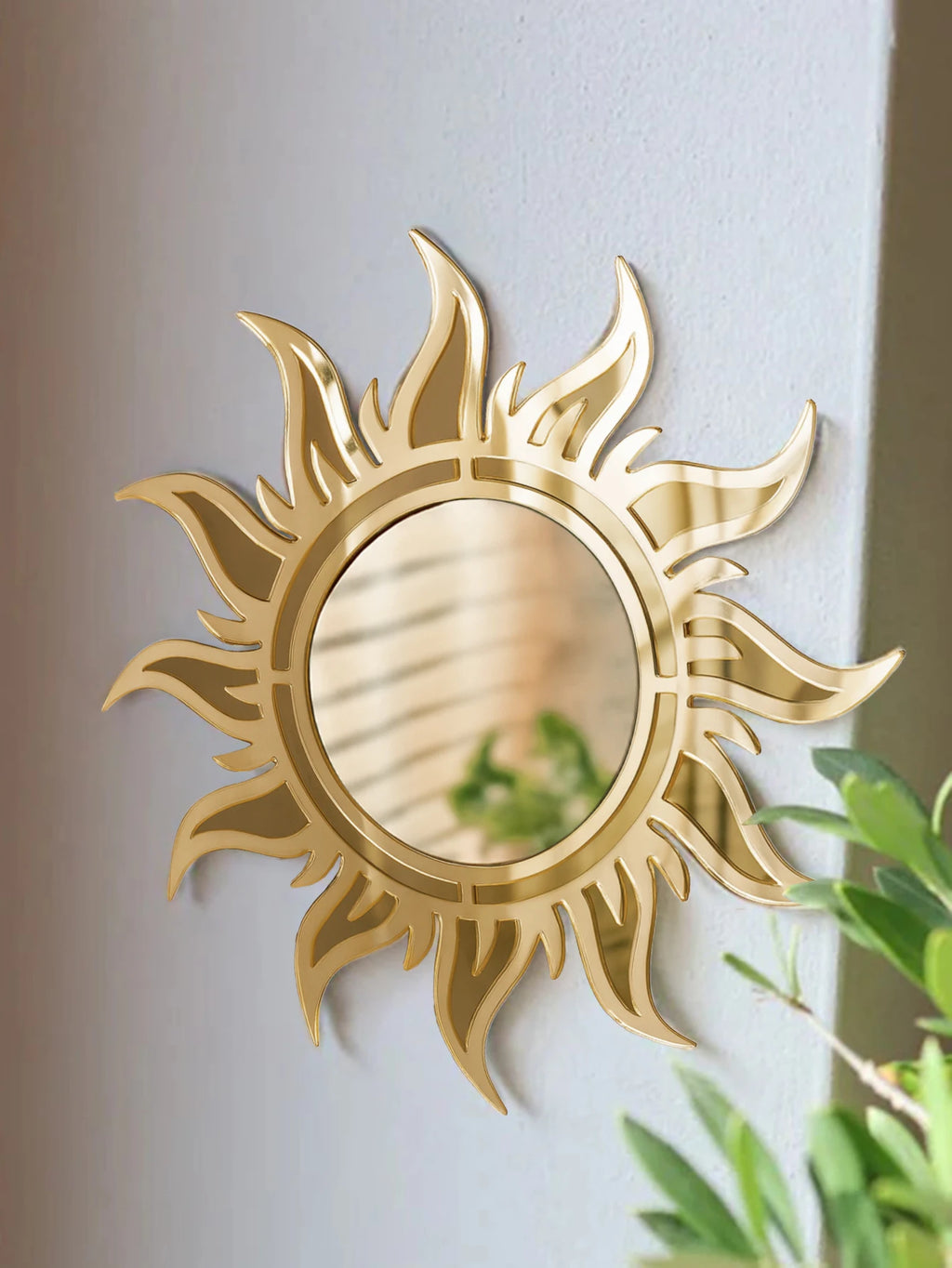 Boho sunburst acrylic wall mirror in gold displayed in a minimalist living space