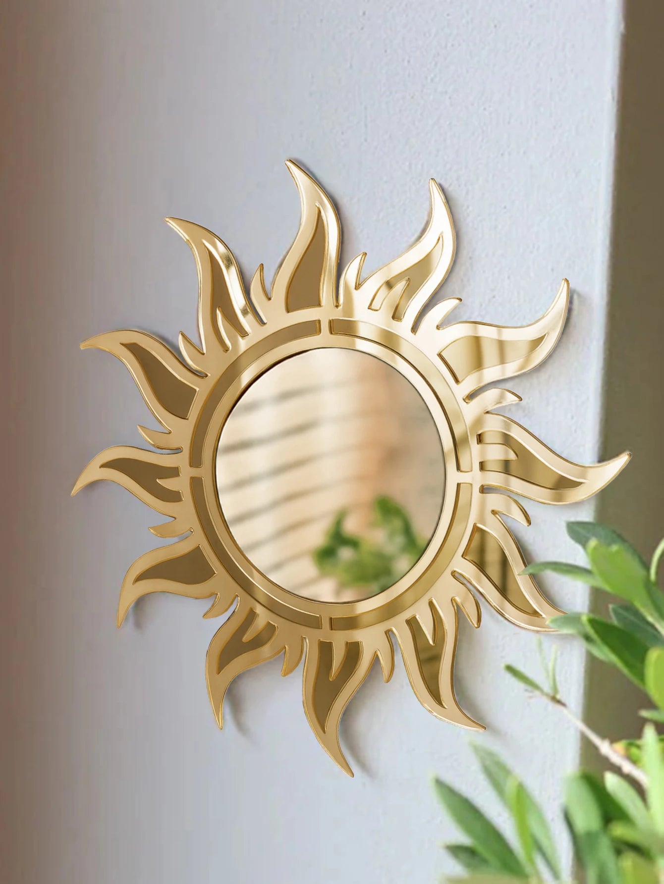 Boho sunburst acrylic wall mirror in gold displayed in a minimalist living space