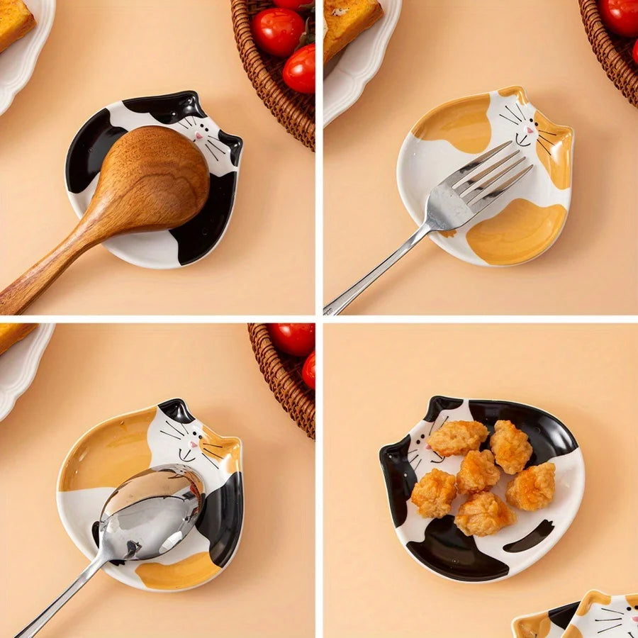 Calico and black ceramic cat spoon rests holding utensils and snacks on kitchen counter