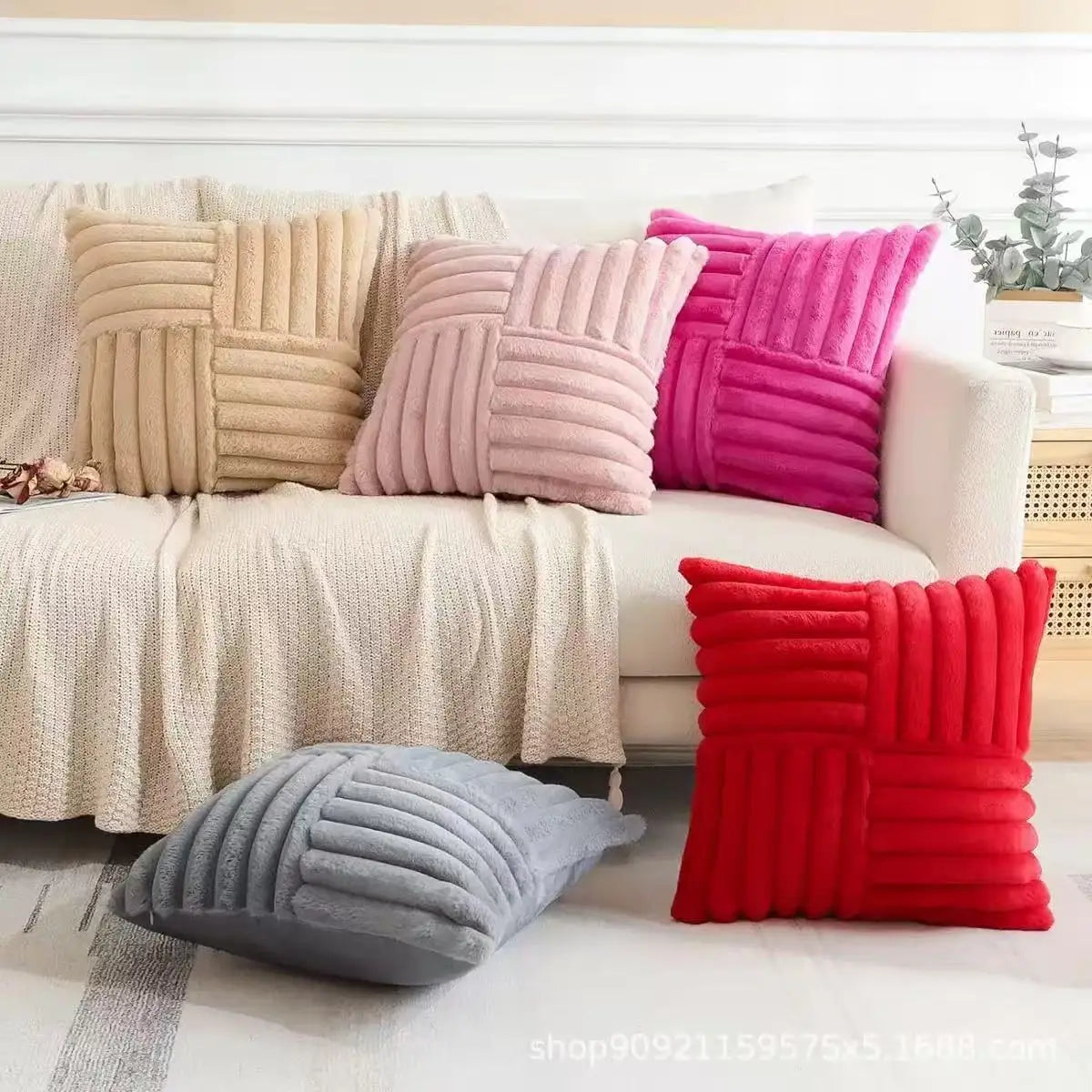Assorted plush geometric pillow covers in beige, pink, gray, and red on a sofa