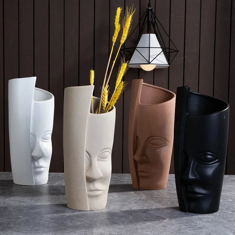 Tall modern face motif ceramic vases in white, tan, brown, and black, styled on a tabletop