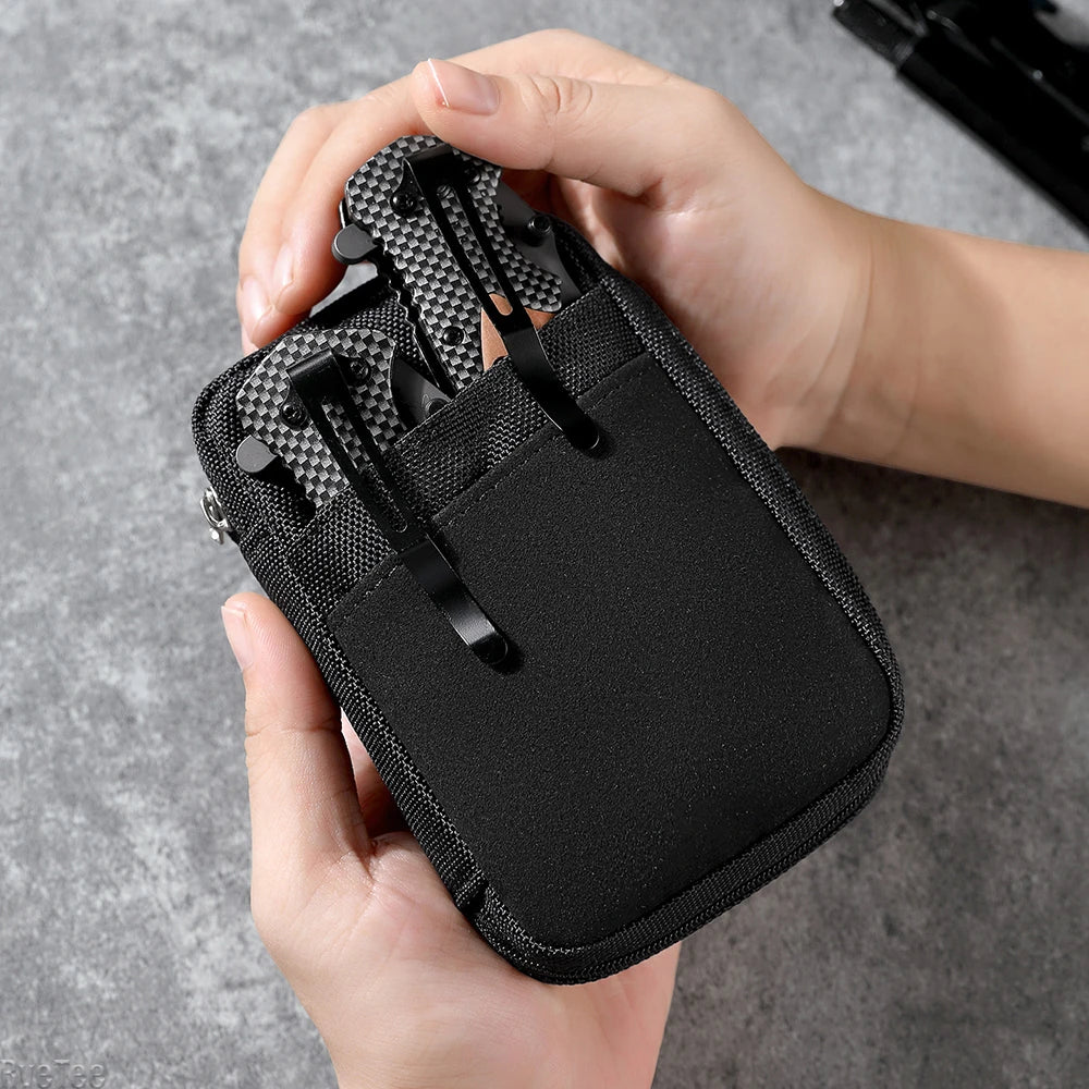 Hand placing multitools in the front pocket of a black organizer pouch.