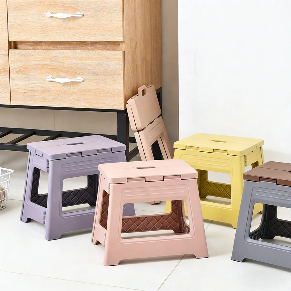 Four folding step stools in pastel colors arranged near kitchen storage, with one stool folded and standing for storage