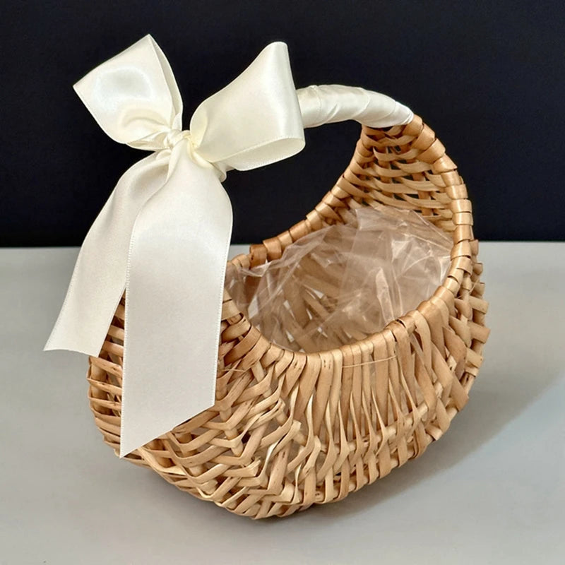 Small moon-shaped rattan basket with handle and cream ribbon bow
