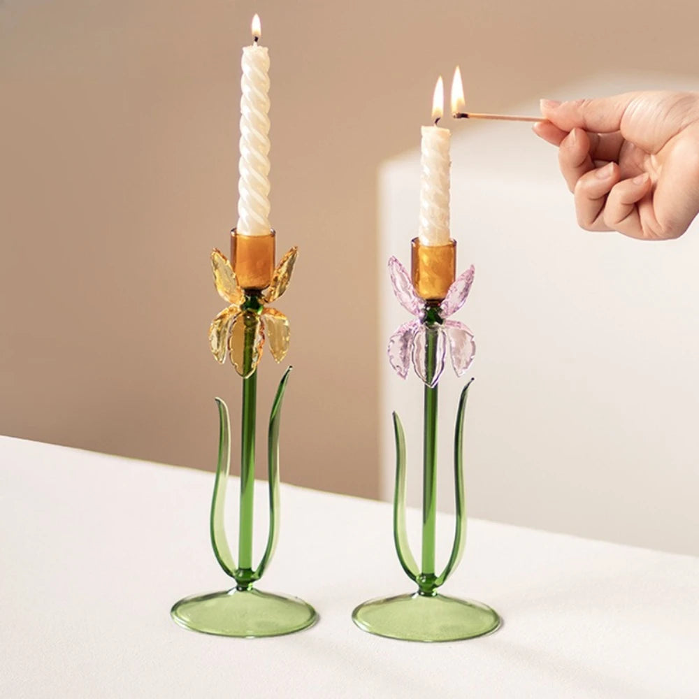 Hand lighting candles in pink and yellow iris glass candle holders
