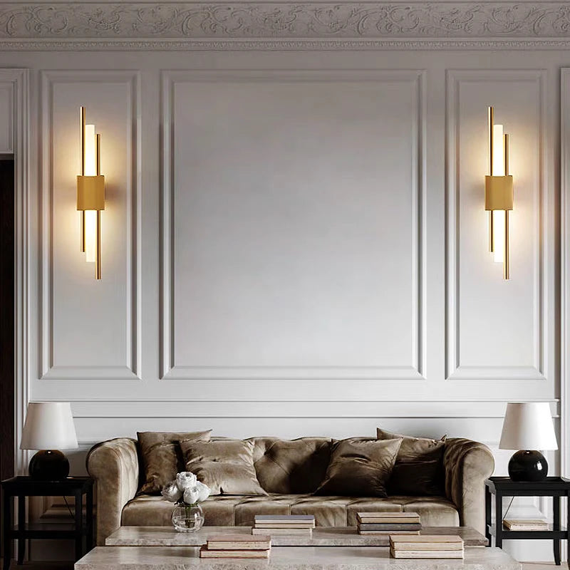 Two vertical gold LED wall sconces on elegant wall in living room