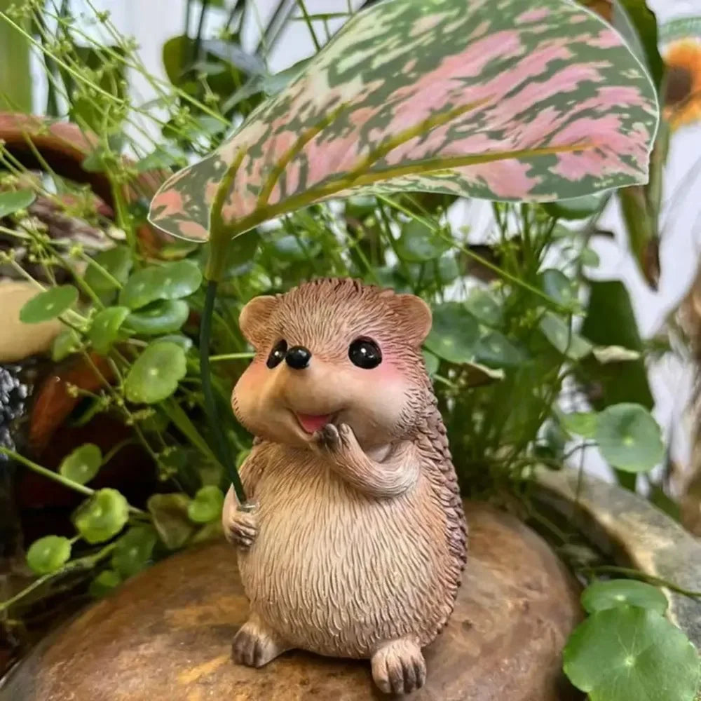 hedgehog resin figurine with leaf umbrella among potted plants