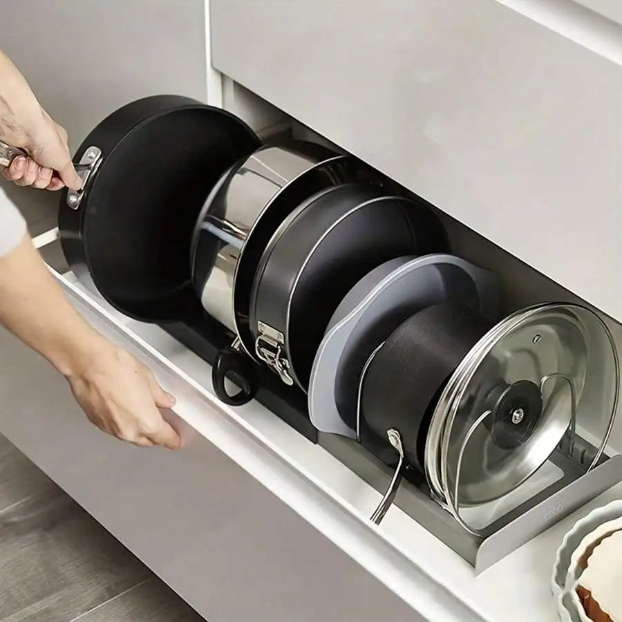 Expandable pan rack holding pots and lids placed inside a deep kitchen drawer