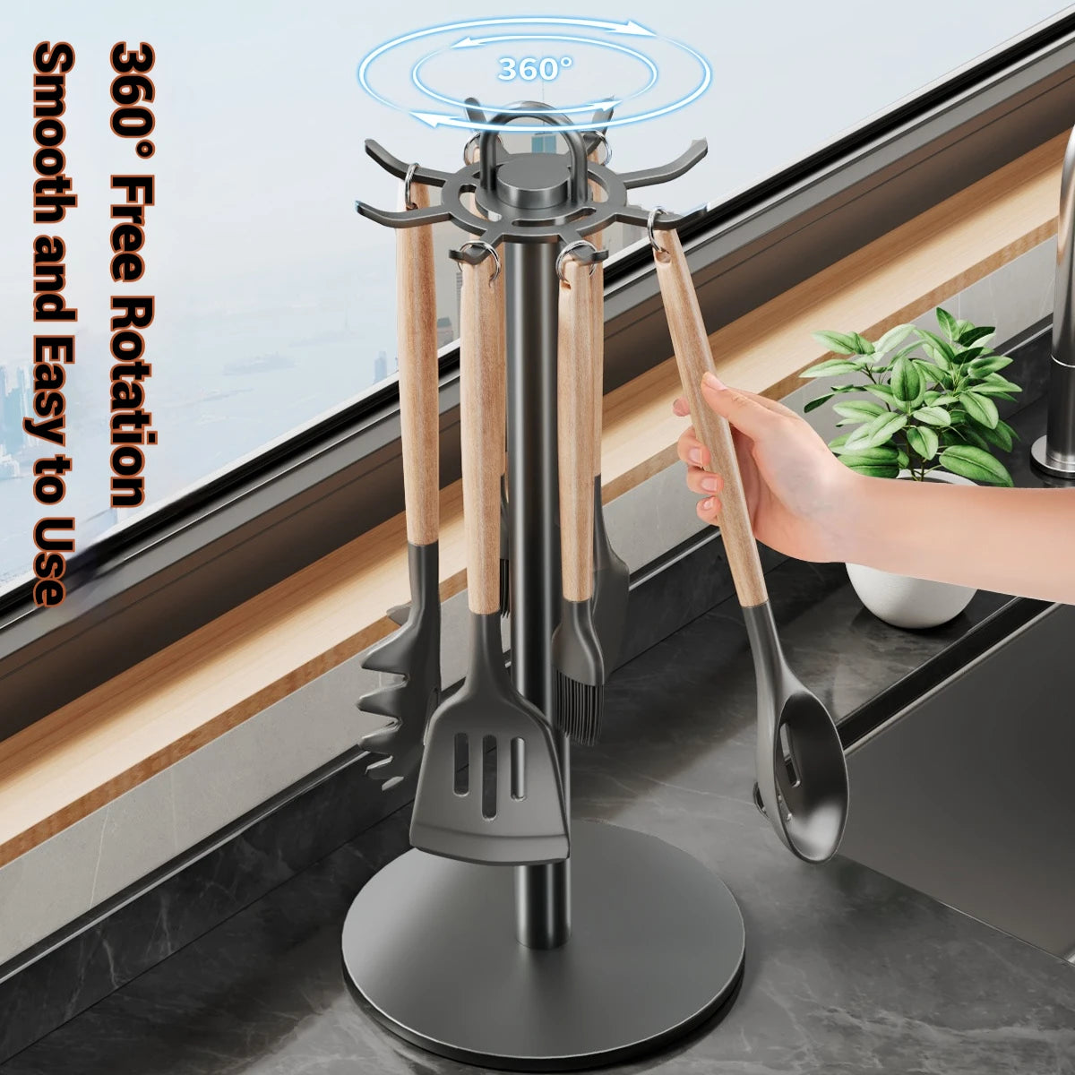 Rotating kitchen utensil holder stand in gun grey on a countertop, holding multiple kitchen tools with a hand reaching for a spoon