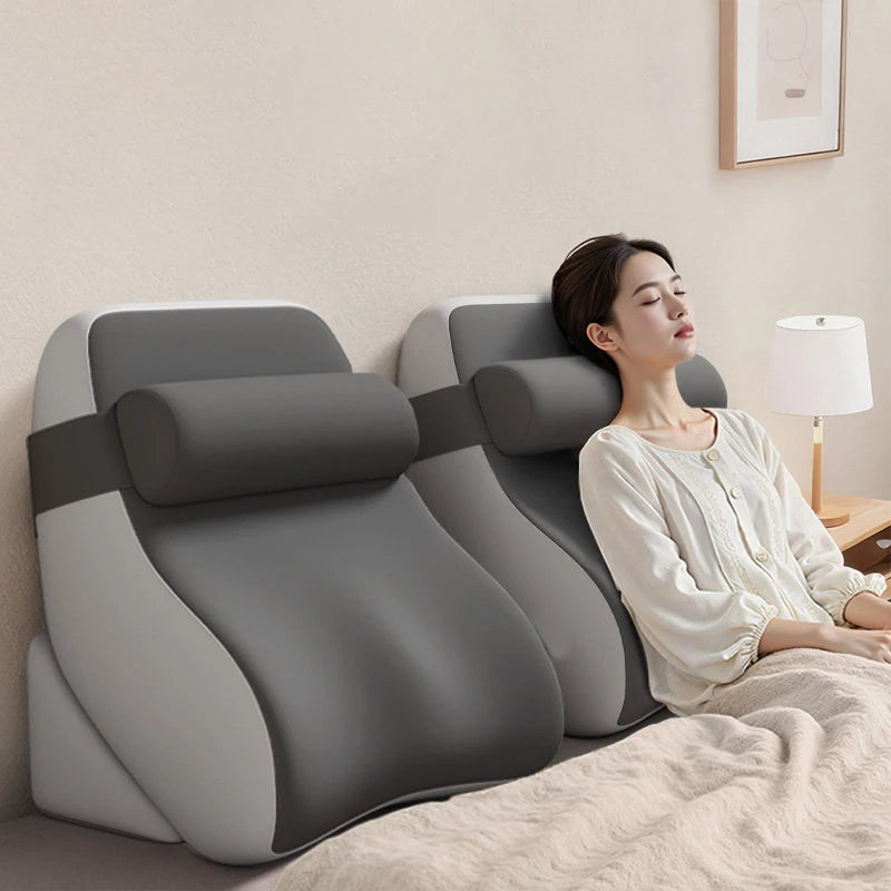 Two ergonomic wedge reading pillows placed on a bed with a person relaxing and leaning back