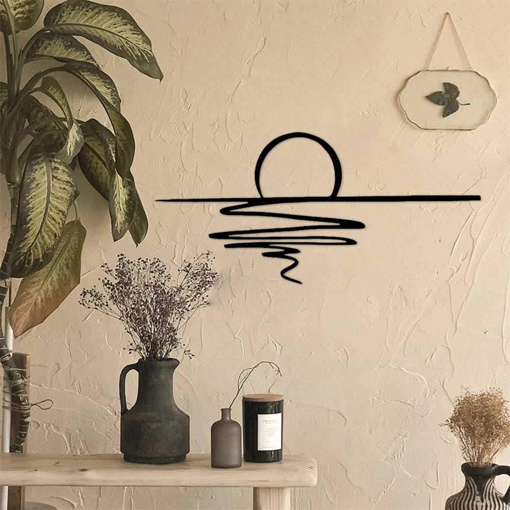Matte black sunrise metal wall art styled above a rustic console table with vases and plants