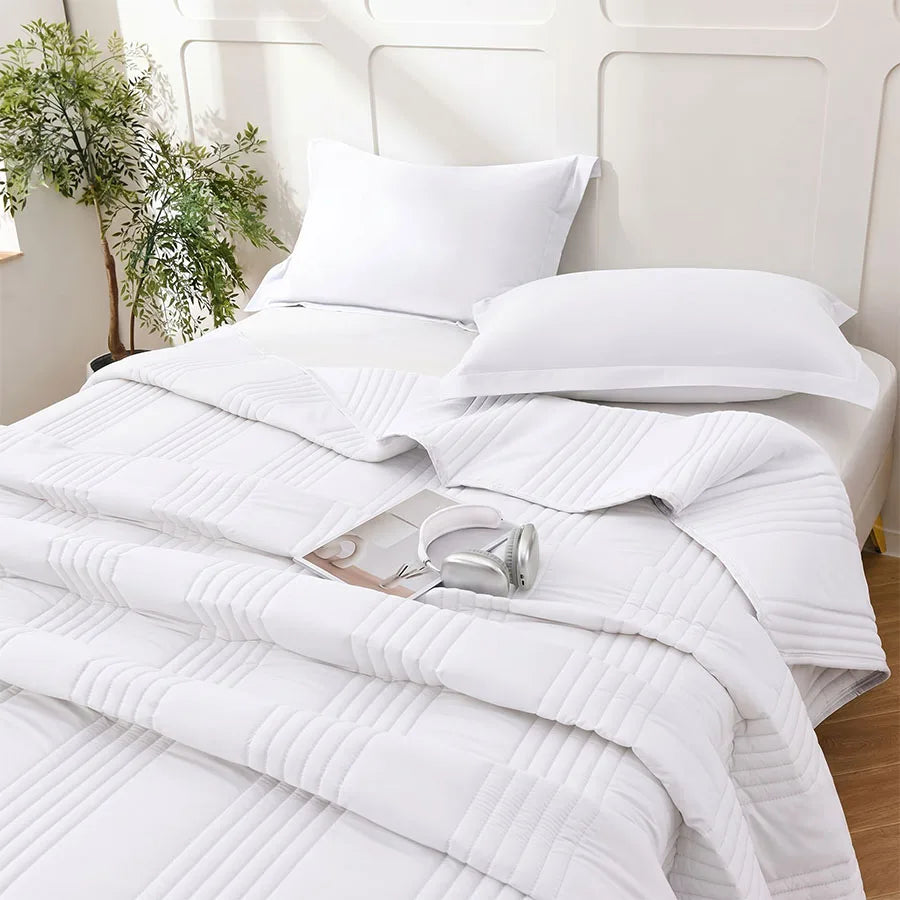 Bed with quilted summer blanket and matching pillow, minimalist bedroom