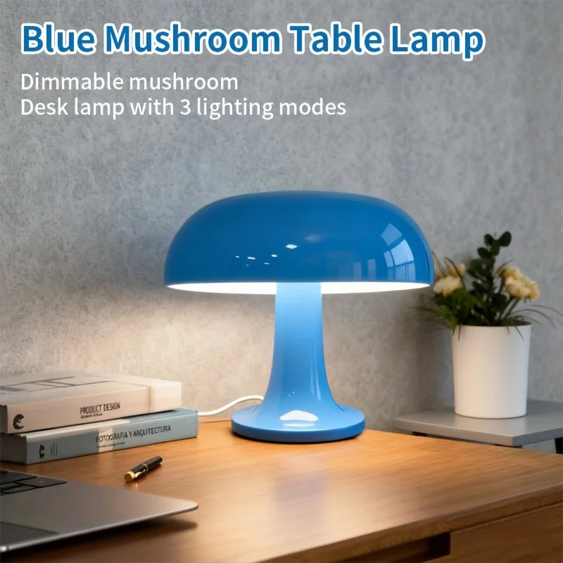 Blue mushroom table lamp on desk with books, laptop, and potted plant in living room setting