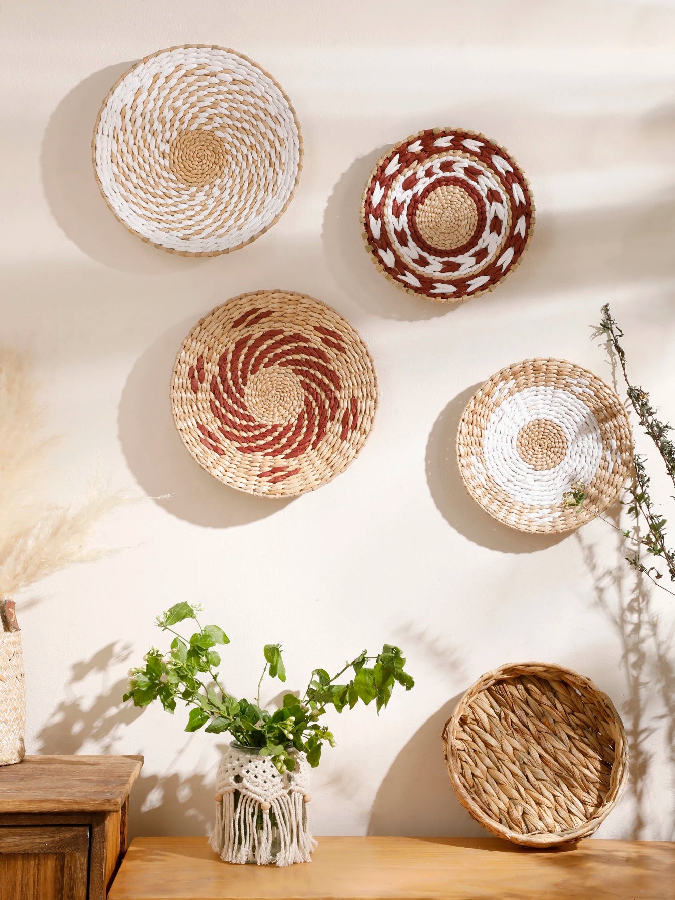 Woven seagrass wall baskets in natural and accent tones displayed above a console in a living room setting