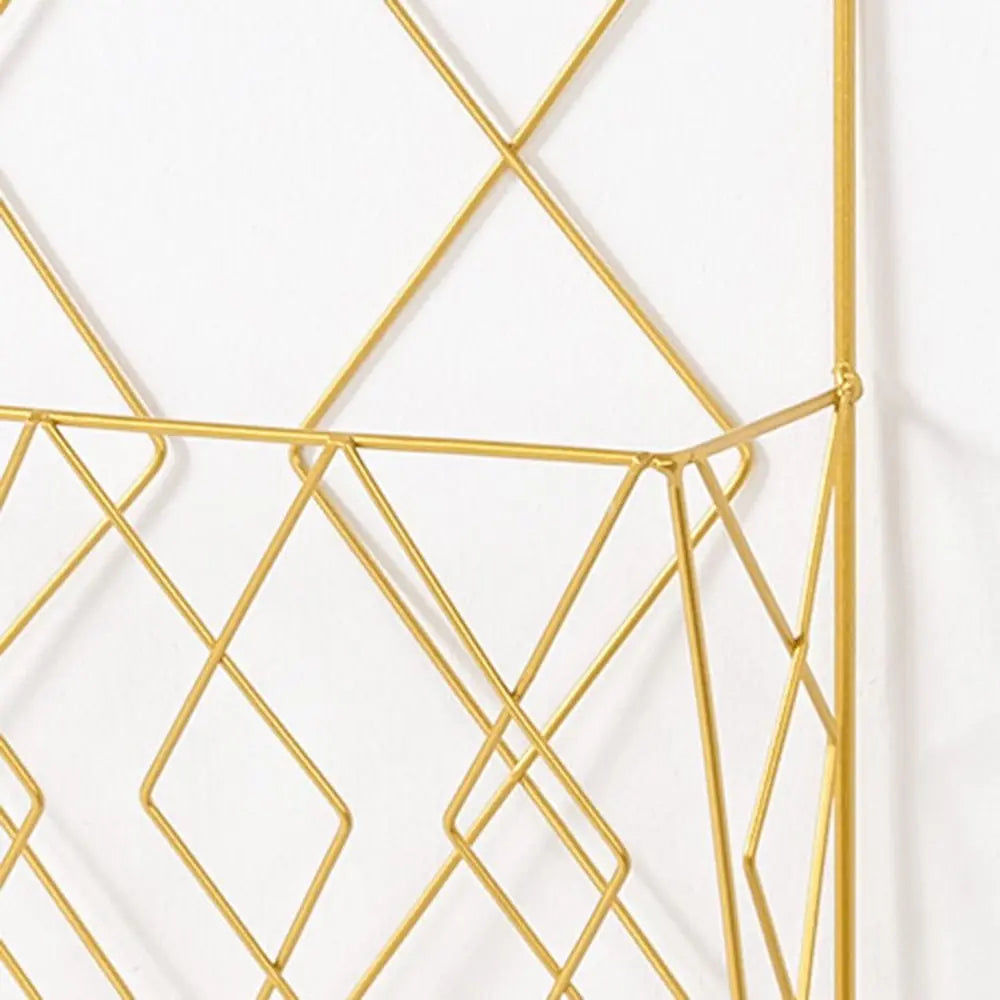 Close-up of gold metal magazine rack, showing diamond grid geometric pattern.