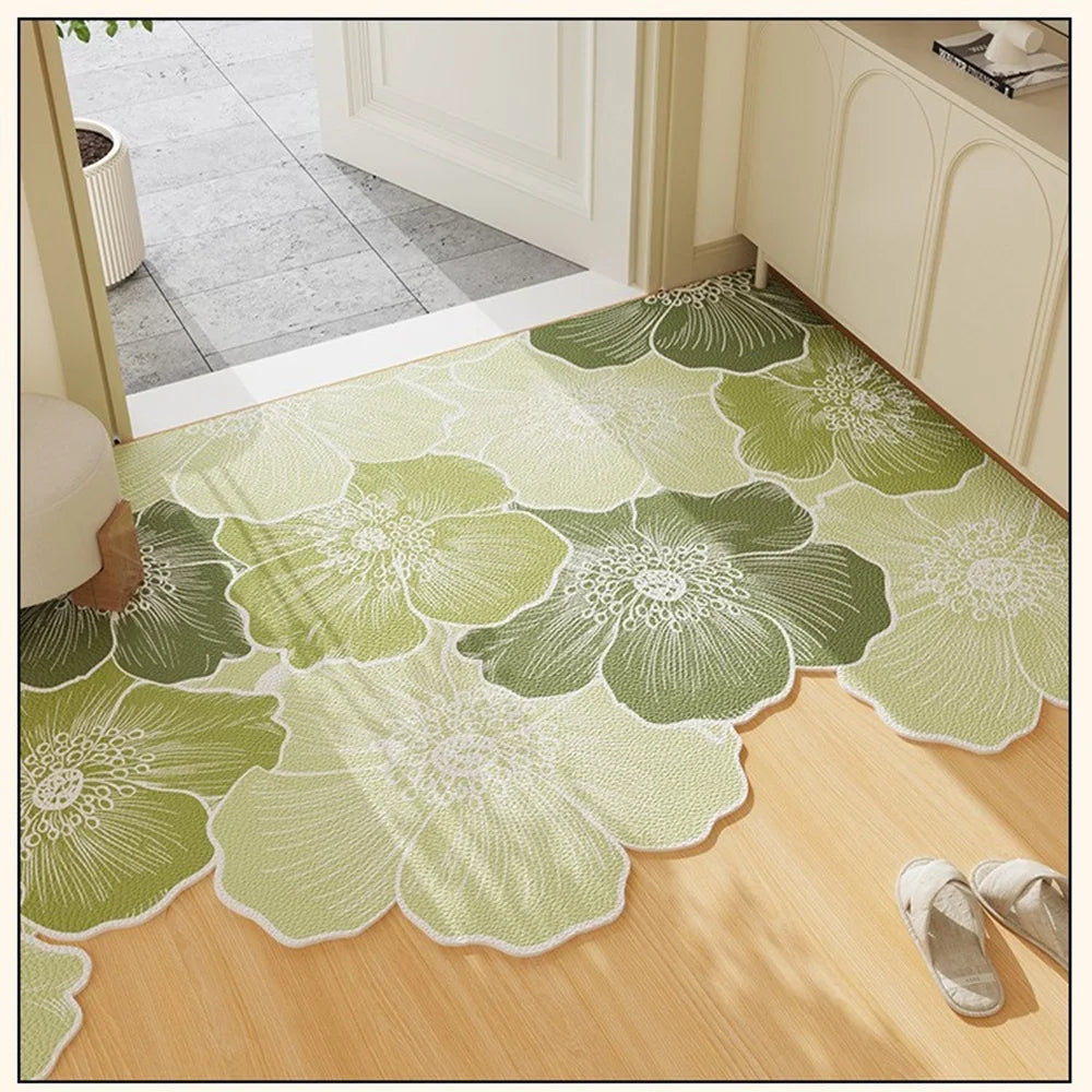 green floral scalloped-edge entryway rug on light wood flooring in sunlight