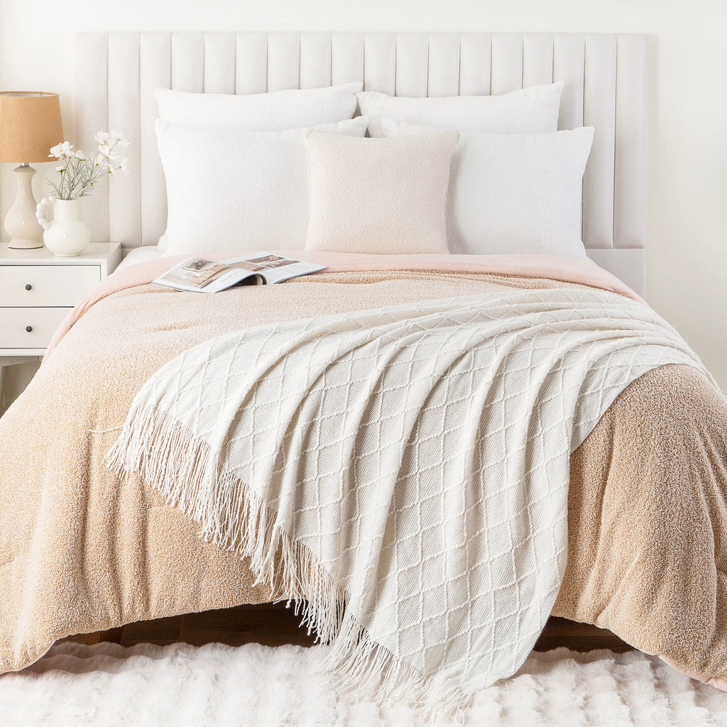 White knit throw blanket with plaid texture draped across a neatly made bed