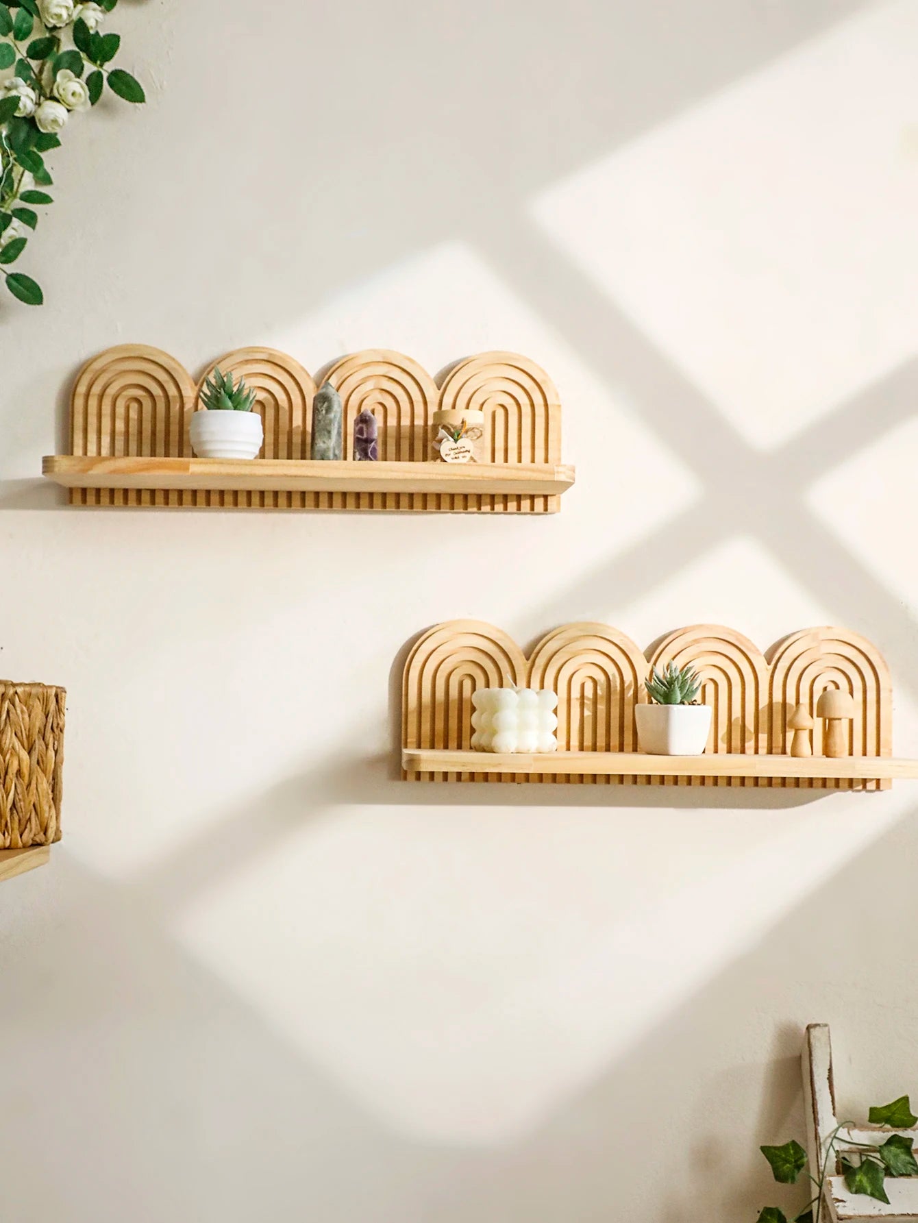 Two arched rainbow wooden wall shelves arranged above each other, decorated with succulents and small ornaments
