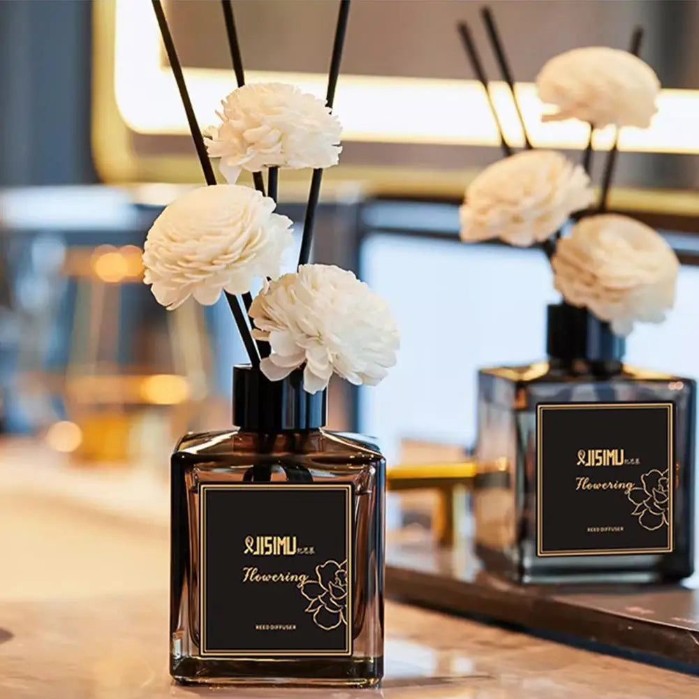 Jasmine reed diffuser set with decorative white flower sticks in a square bottle, placed on a bathroom counter