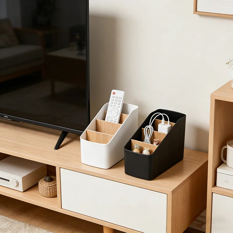 White and black tabletop organizers on a living room media console, holding remotes, chargers, and small items