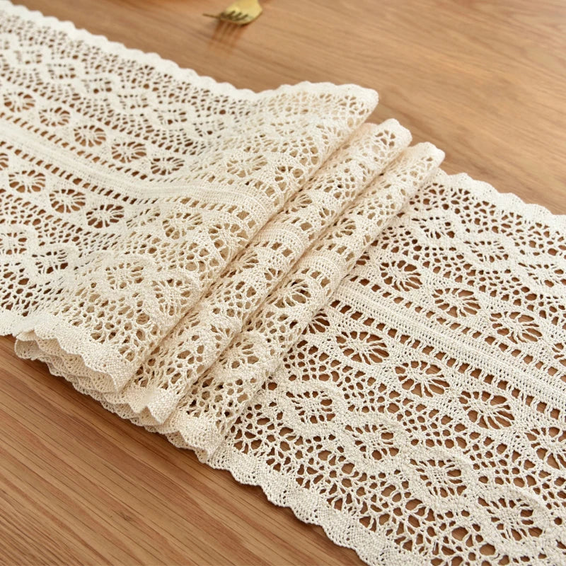 Close-up of folded beige cotton-blend crochet lace table runner on wood table