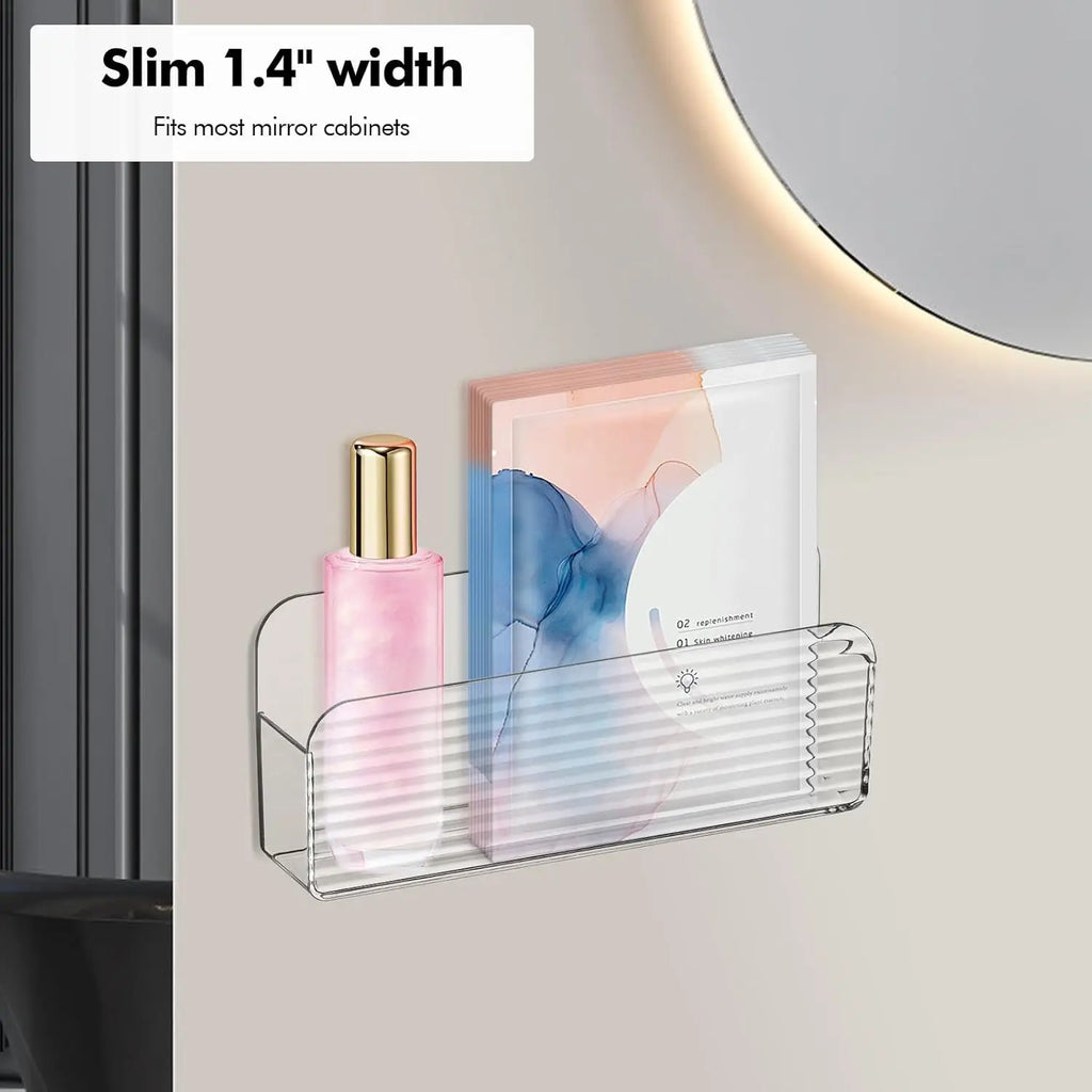Slim clear storage bin mounted by a bathroom mirror, holding a bottle and packets