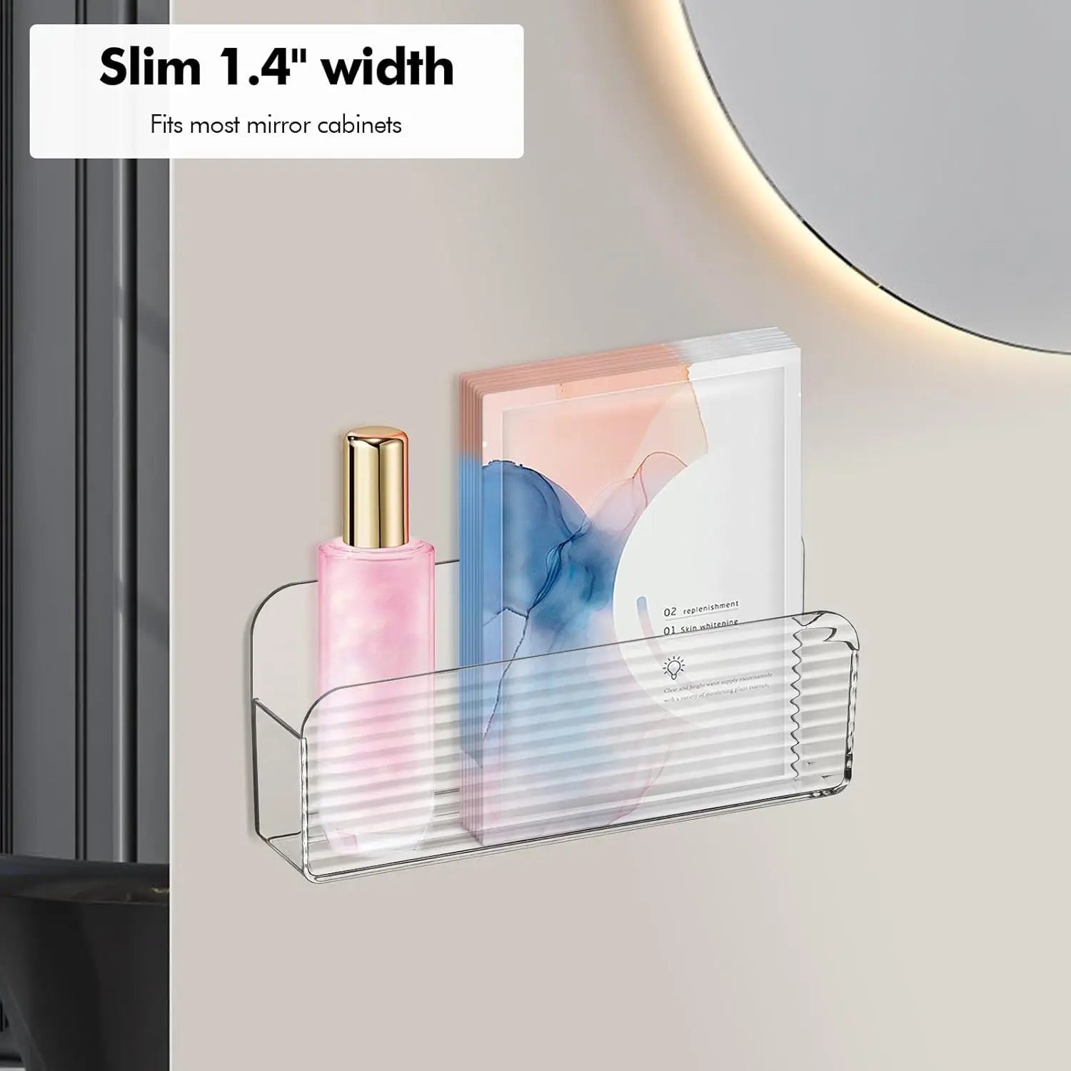 Slim clear storage bin mounted by a bathroom mirror, holding a bottle and packets