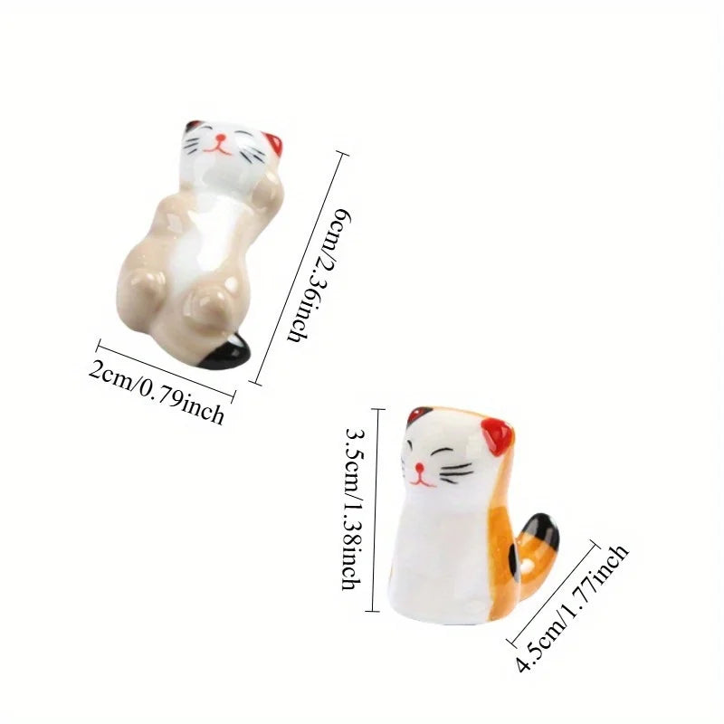 two ceramic cat rests with visible size measurements in centimeters and inches