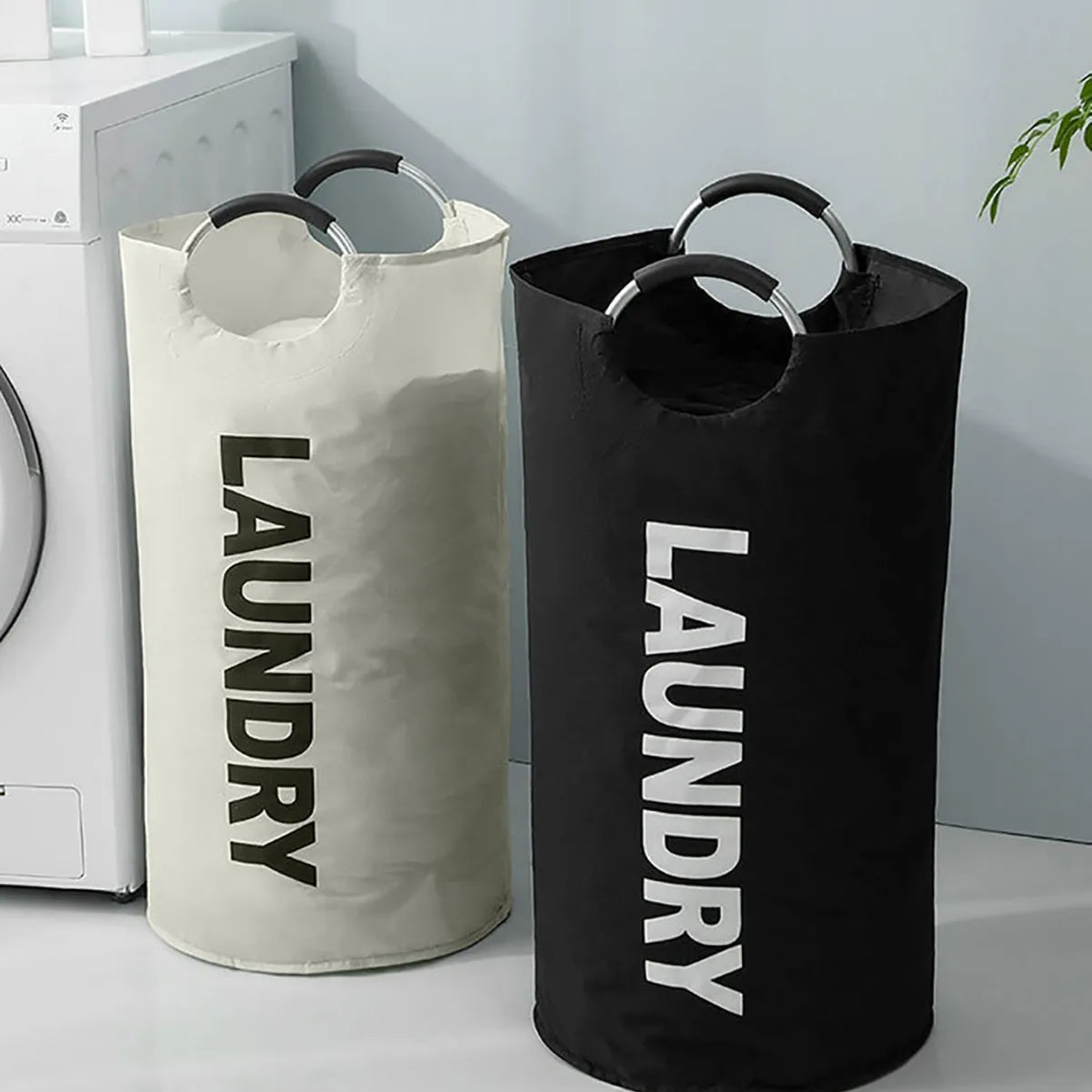 Two large waterproof laundry baskets with 'LAUNDRY' print, beige and black, beside a washing machine