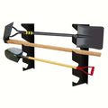 Wall-mounted metal tool rack holding long-handled shovels and garden tools on a white wall