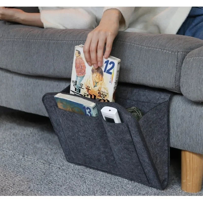 felt sofa caddy organizer holding books and a remote on a gray couch