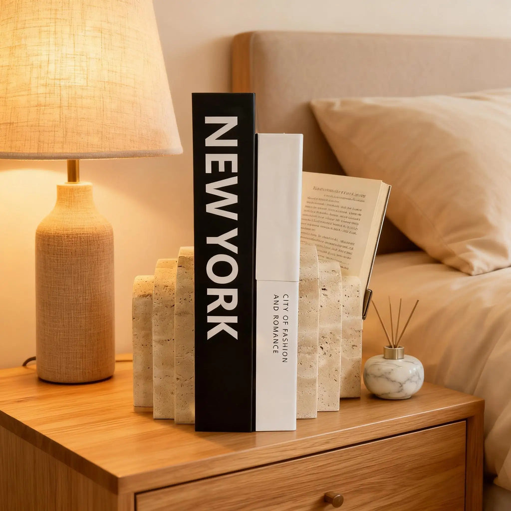 Travertine marble bookend in modern arch design on a bedside nightstand with lamp and neutral bedding