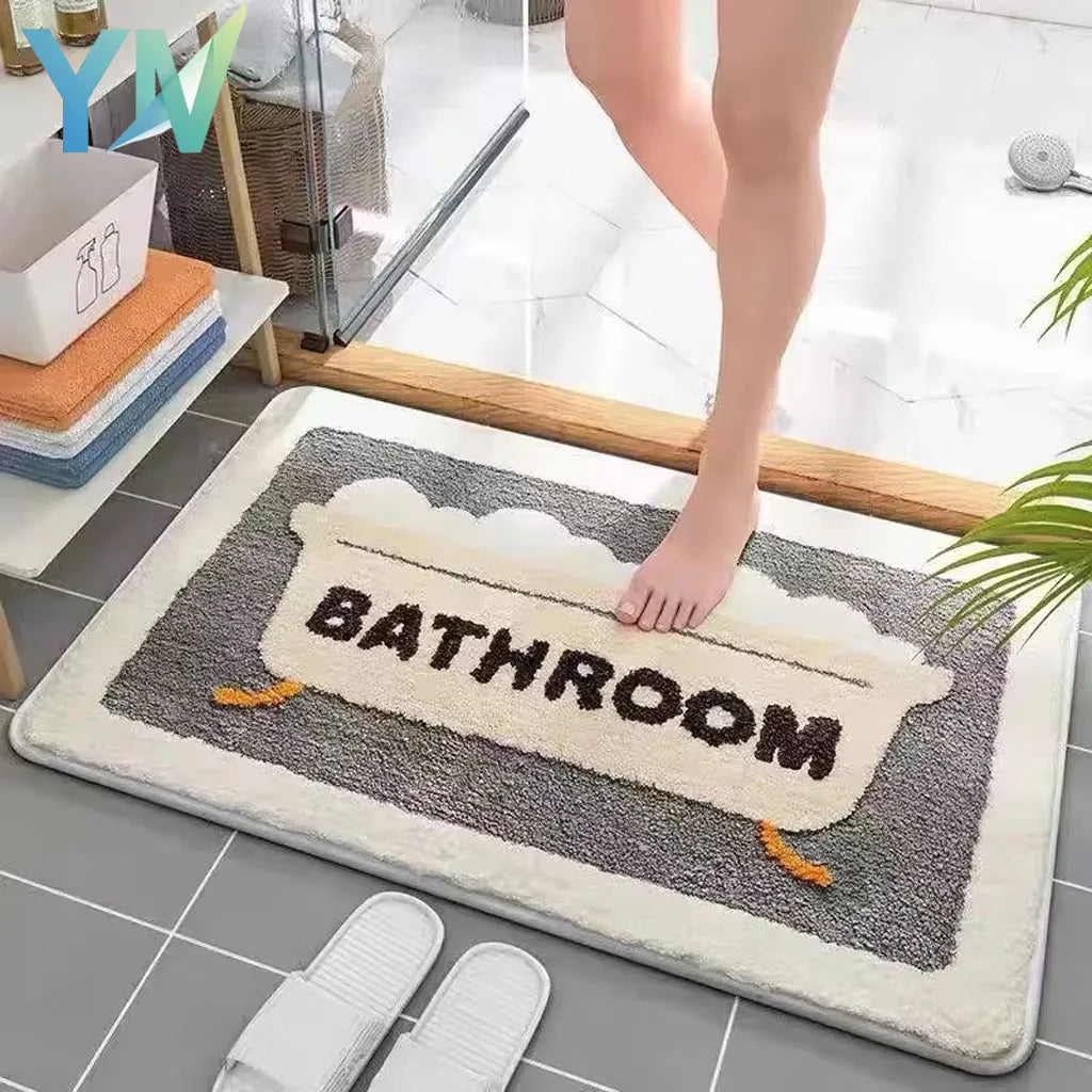 Rectangular faux wool bathroom mat with bathtub motif and 'BATHROOM' text in front of a shower door.