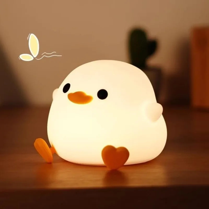 Soft silicone duck night light glowing on a bedside table