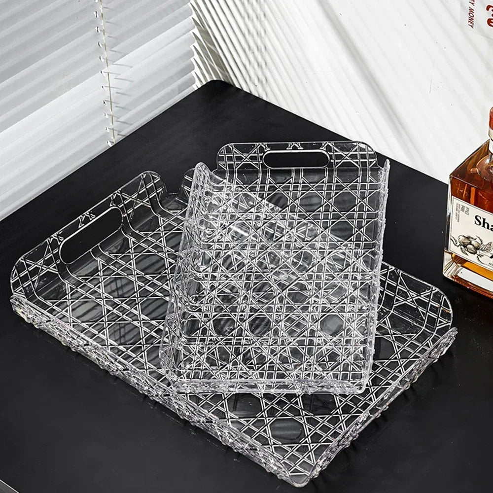 Two clear geometric trays, one nested inside the other, displayed on a table under sunlight