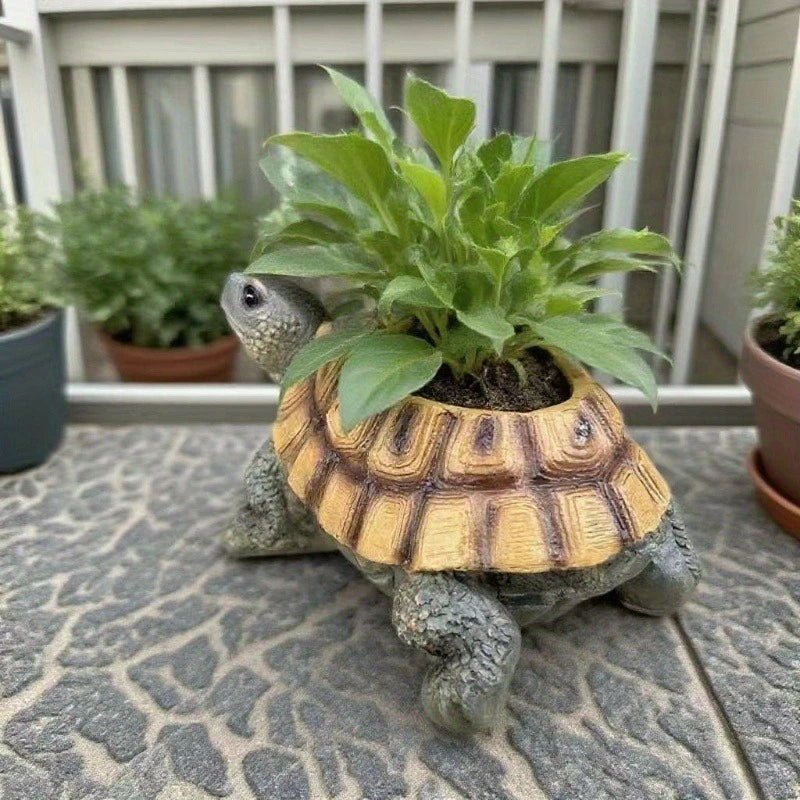 Resin turtle-shaped planter holding a leafy plant on a tiled balcony