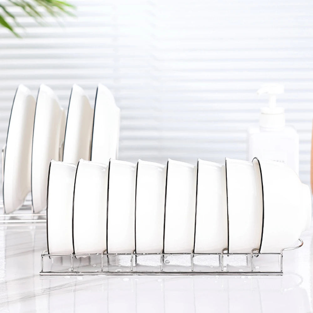 side view of stainless steel dish rack holding eight white plates on a countertop