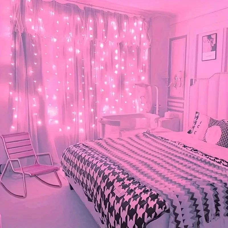Pink curtain fairy string lights illuminating a cozy bedroom window