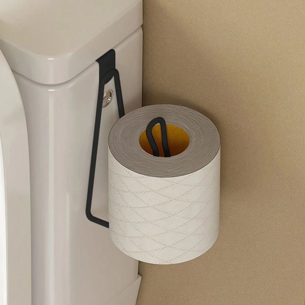 black metal over cabinet toilet paper holder hanging on a toilet tank in a bathroom
