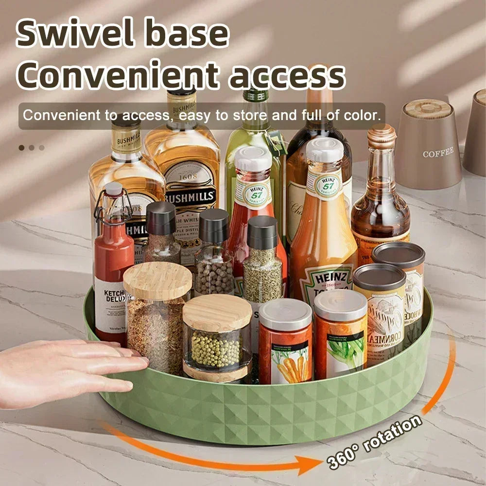 Green rotating Lazy Susan turntable filled with spice jars, sauces, and bottles on a kitchen counter